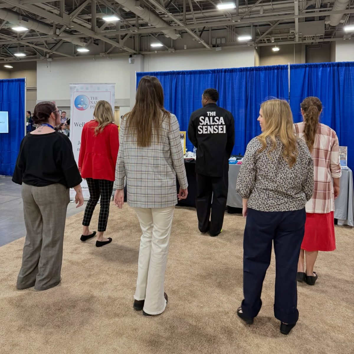 Attendees at a Salsa Therapy conference booth